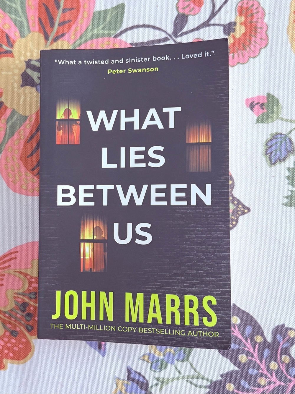 What Lies Between Us by John Marrs - Black Cover with Neon Yellow Title